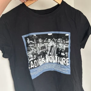 Zadig Voltaire T-shirt  - Svart Zadig Voltaire T-shirt med blått tryck på framsidan. Storlek XS. Bra skick eftersom jag inte använt tröjan så många gånger. 