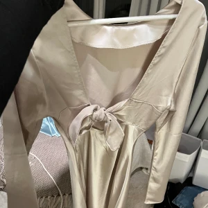 Satin klänning  - 🎀Säljer nu denna underbara klänning🎀 Storlek M!!🌸 Beige satin klänning🌸 Köpt på Gina tricot och använt en gång därav väldigt fint skick!🙏🏼🙏🏼