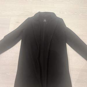 En svart kappa i storlek s, ordinarie pris 700 säljer för 500