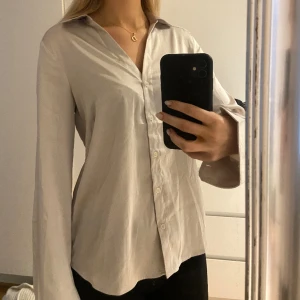 Satinskjorta - Säljer denna snygga skjorta i satinliknande material, från h&m. Färgen är beige/champagne (syns bäst på sista bilden) och Storlek xs. Använd en gång så därför är den i väldigt bra skick. Säljer för 179kr. 