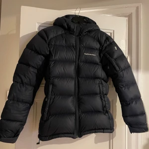 Peak Performance Down Jacket Dam - En fin marinblå dunjacka i strl. XS som inte visar några täcken på användning. Säljer då jag inte har haft användning av jackan!
