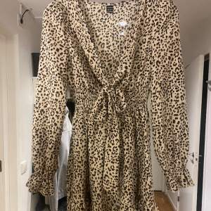 Jätte fin sommar klänning i leopard mönster med rosett knytband fram ressår i midjan och volanger i armarna och ner till, helt ny 