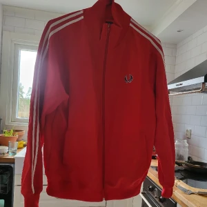 Fred perry träningsjacka -  fred perry träningsjacka, pyttelite skrap på dragkedjeflärp (se bild) annars i superfint skick, har knappt använt.. dessa går vanligen för 700-900 kr  begagnade i samma skick.