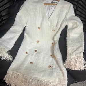 Vit klänning med guldknappar - Säljer denna söta klänning från SHEILAY💗 Nypris 450kr men säljer för 200kr. Storlek M Klänningen är i Ny skick 😍   