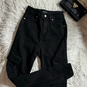 Helt nya svarta jeans  - Med stora fickor på sidan. Liten i storlek