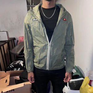 Ellese vindjacka grön - Säljer en super fin ellese jacka storlek M i nytt skick, finns absolut inga deffekter på jackan. Vid frågor eller pris diskutering är det bara att höra av er!