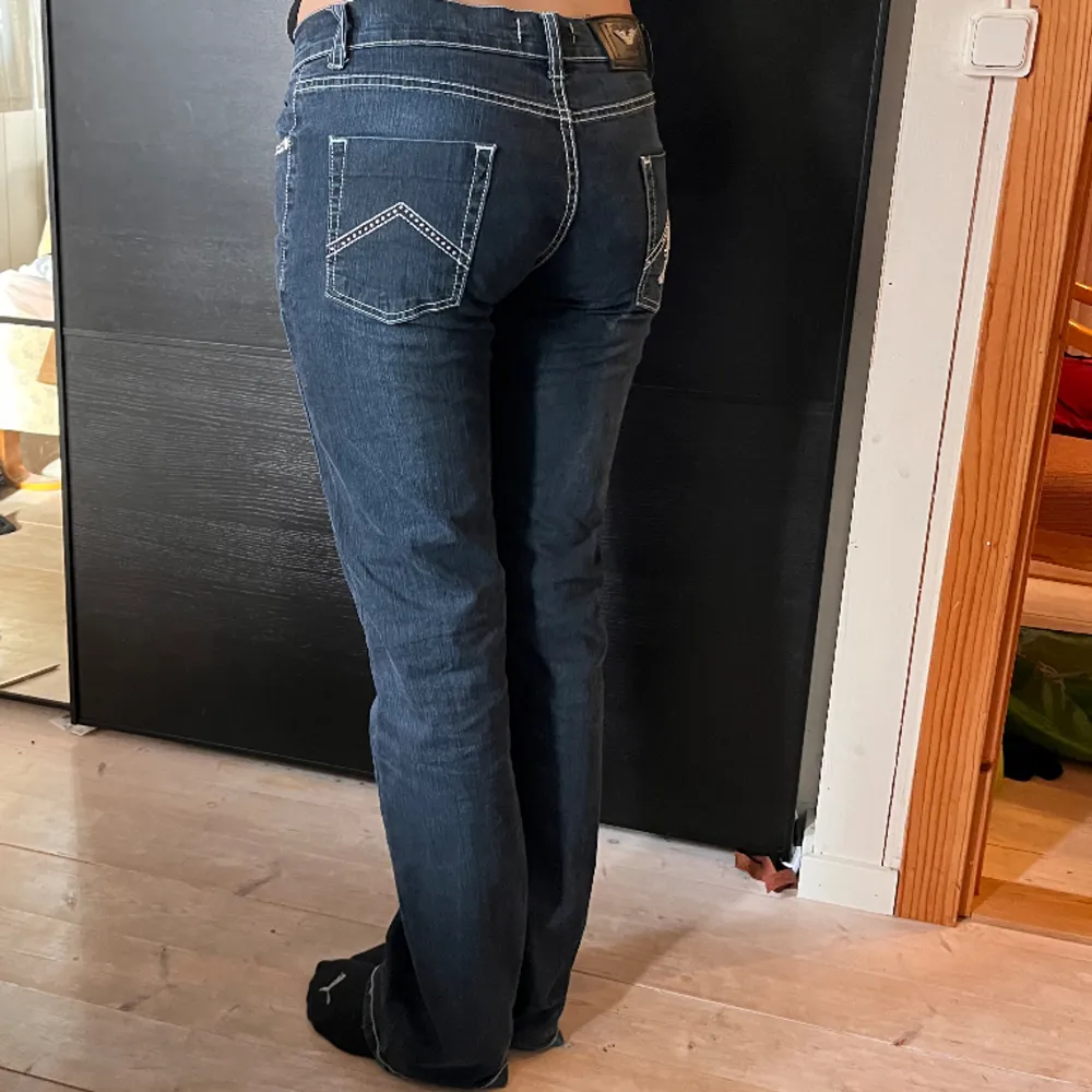 Mörkblå jeans från Armani med vita sömmar. Passformen är rätt raka men lite utsvängda nertill. Jeans & Byxor.