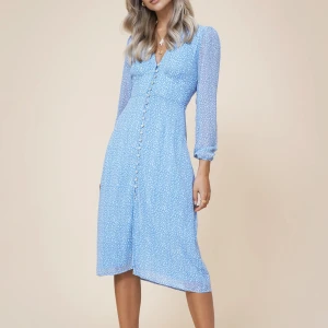 Adoore klänning - En blå vit klänning från Adoore. Klänningen har en v-ringning och knappar framtill. Den har långa ärmar och en figursydd passform. Klänningen är använd men i ett fint skick.