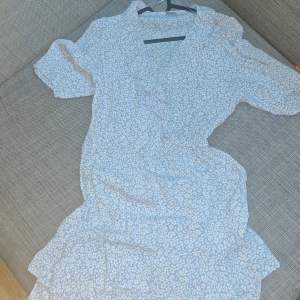 Blå klänning med volang från Indiska. Klänningen är i nyskick, används 1 gång.  https://www.indiska.com/se/mode/klader/klanningar/omlottklanningar/bla-klanning-med-volang-111069908ltblue 