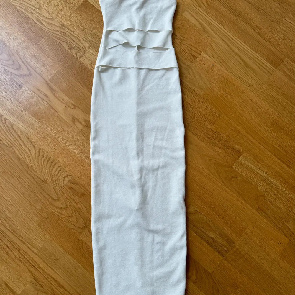 En helt oanvänd vit tight klänning från Zara. Bandeau-modell med cutouts vid magen och slit där bak🤍. Klänningar.