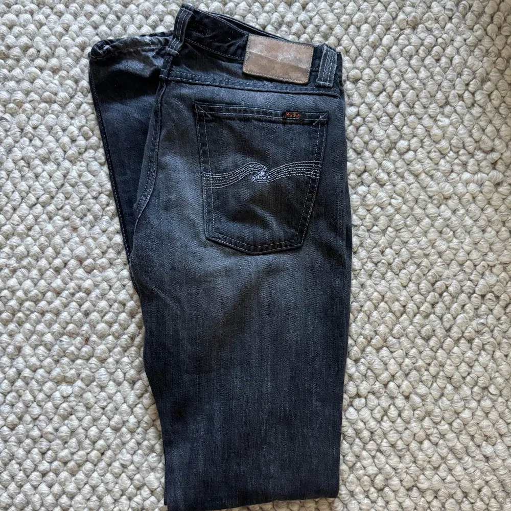 Supersnygga lågmidjade vintage jeans från nudie i en mörkgrå/svart färg. . Jeans & Byxor.