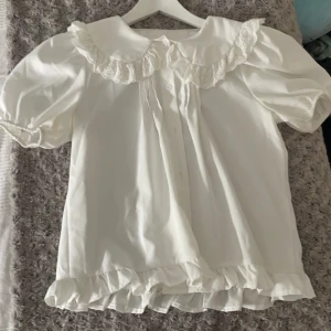 Vit skjorta  - Jättefin vit skjorta med mönstrad krage som passar bra för vår/sommar/ tidig höst  Är använd några få gånger och har en liten svart fläck (kontakta för info), men annars är det inte märkbart, och den är i fint skick.