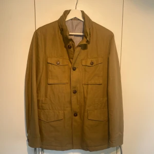 Massimo Dutti Kavaj/Jacka i olivgrönt Linne - Hej, säljer en sjukt fräsch linne kavaj/jacka i linneblandning. Olivgrön/khaki färg, storlek M. Stilsäker & passar till allt! Nypris 2200kr. Zip och knappar. Mycket små snygga detaljer. Justerbar midja. Luftig & perfekt för sommarkvällar. Hörs i DM! 