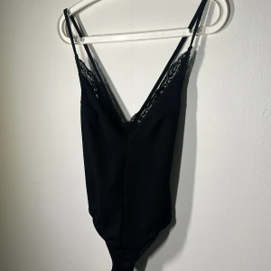 Svart body med krossad rygg - Snygg body använd 1 gång. Väldigt fint skick!