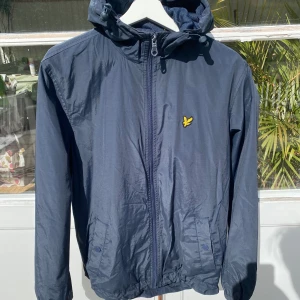 Lyle & Scott Vindjacka Marinblå - Hej, säljer en vindjacka från Lyle&Scott i marinblå färg. Välanvänd och i dugligt skick med små tecken på användning. Storlek M och true to Size. Perfekt för varmare väder. Snygg blå färg som passar till det mesta. Nypris 1200kr. Pris kan diskuteras. Hör av dig vid intresse! 