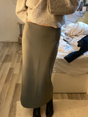 Grön maxikjol - Svinsnygg rak maxikjol i fin militärgrön färg, skönt och löst material. Kan sitta båda högre och lägre på midjan, blir bra lågmidjat på mig som brukar ha S. Perfekt skick, slits där bak! Köpt vintage 