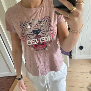 Kenzo t-shirt - Kenzo t-shirt i storlek XS i en jättefin ljuslila färg. Nypris ca 1500kr. Använd några gånger men i väldigt fint skick. Pris går att diskutera😍