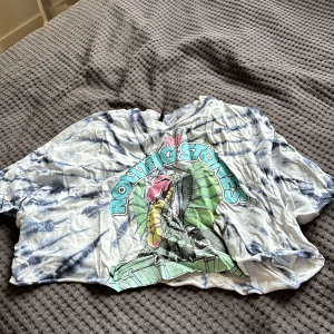 t-shirt - Blå med en bild på drake med texten rolling stones. cropad tunn t-shirt