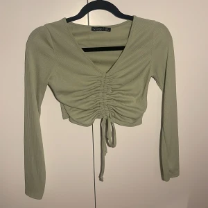 Grön topp - Inte använd så många gånger, 4-6 ggr? Fint skick. Kan justera själv hur ”tight” eller kort banden ska vara - magtröja. Mjukt och fint material.  Märke boohoo