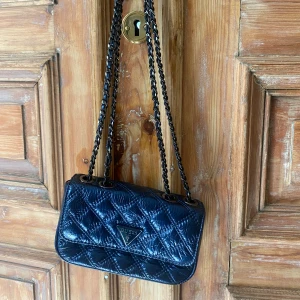 Handväska - Liten handväska från Guess i blå metall färg. Använd 2 gånger och säljer för att den inte kommer till användning. 