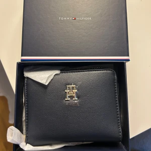 Plånbok , korthållare - Helt ny Tommy hilfiger plånbok, fick i present och var fel modell så tänker att jag säljer den och köper den jag vill ha. Svart/ marinblå