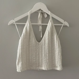 Vit topp  - Jättefin stickad topp från zara i storlek M. Den har ett jättefint knyte man sätter runt halsen och toppen är i fint skick!