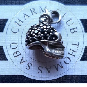 THOMAS SABO/DÖDSSKALLE. - Thomas Sabo berlock, riktigt häftig o speciell dödsskalle m stenar. Ask/påse ingår ej.  Kolla bilder o ställ ev frågor före bud.  Frakt tillkommer.  (Sista bild från hemsidan).