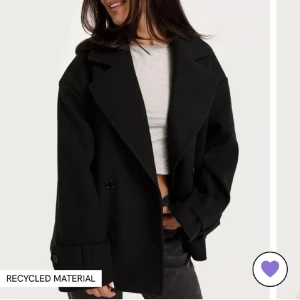 Kappa från Nelly strl S - Jättefin svart kappa från Nelly som har många fina detaljer i strl s men är lite oversized