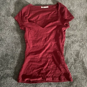Anna Feild T-shirt med print mörkröd - Tröjan är i storlek XS och har kommit till användning en gång sedan jag köpte plagget. Den är i fint skick och passar även storlek S. Jättefin vinröd/mörkröd färg och formar sig efter kroppen fint.    Original pris 189kr 