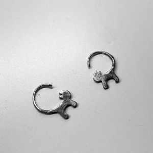 Silverörhängen - Örhängen av sterlingsilver formade som katter. Huggies där svansen på katten träs igenom örat. Följer med pluppar till baksidan av örhängena. Pris kan självklart diskuteras!