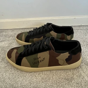 Saint Laurent sl/06 - Tja! Säljer nu dessa sprillans nya Saint Laurent Sl/06 skor i den eftertraktade Camo modellen!  (Endast prövade 1 gång) Storlek = 43  Skick = 10/10, Ny skick!  Säljs för 3999kr! Bara att skriva vid övriga frågor!