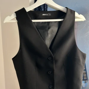 Svart väst - Asball svart väst från Gina Tricot i superhärligt tyg. Perfekt att jobba upp layers med och riktigt snygg att ha bara som den är! Aldrig använd. Hör av dig vid funderingar!🫶‼️