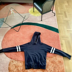 Ami Paris hoodie / huvtröja - Hoodie från märket Ami Paris. Inköpt för 2490 kr, kvitto finns tyvärr ej sparat. Tyvärr lite för liten i storleken, hade gärna behållt den annars!   Tillverkad i: Portugal Färg: Navy Material: 80% bomull, 20% polyester Defekt: urtvättad