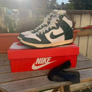 Nike Dunk Spartan Green - Tja säljer ett par Dunks jag knappt använt, köpte dem för typ två år sedan och glömt bort dem. Har bytt snören och målat om sulan för jag tyckte det va snyggt. Jag slänger med ett par creeseskydd 