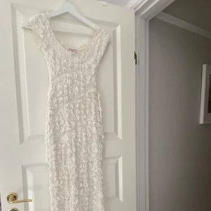 Vit figursydd klänning - Suuuuuuperfin klänning i ”puffigt” tyg, stretchig så passar XS-M. Använd endast en gång på min studentmottagning, inga som helst defekter. Justerbar midja, beige/vit färg.  Köpt för 1000kr!!