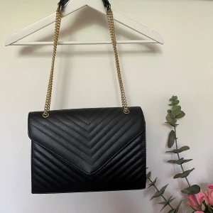 Väska  - Svart väska med gulddetaljer, väskan är i måtten 28x22x6 Superbra strl  Går att ha som crossbody eller på axeln 🌸