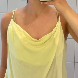 Gult linne - Jättefint gult linne med ”häng” därframme från NA-KD, använt en gång. Perfekt till sommaren!☀️ Skriv gärna om ni har frågor eller vill ha fler bilder!💕