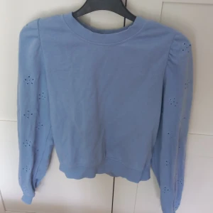 Blå tröja - Säljer en blå tröja med blommor på ärmarna. I storlek xs från H&M. Använd 1 eller 2 gånger