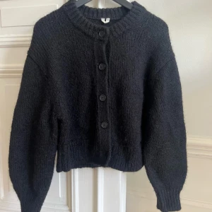 Stickad tröja Arket - Stickad svart kofta från Arket men knappar fram i storlek xs dam. 50% mohair och 50% polyester.