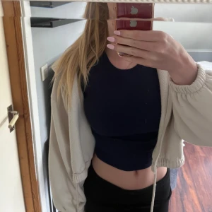 Croppad zip-up - Säljer denna krämvita zipup hoodie med luva som inte längre används, jättemysig att dra på sig på sommarkvällar. Den har inga defekter, går ner i pris endast vid snabba köp🤍