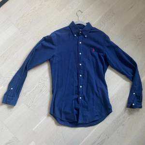 Nu säljer vi en mörkblå Ralph lauren skjorta i väldigt bra skick. Skjortan bör passa dem mellan 174-178cm. Priset kan diskuteras. 