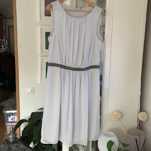 Klänning Benetton - Oanvänd klänning i ljusgrått från Benetton. Storlek L. Nypris 65 euro. Fint glitter i midjan, kan skicka fler bilder 