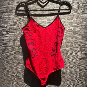 Body | Guess - En fin, äkta röd och svart body från märket Guess. Denna är väldigt formfitting och framhäver därför midjan väldigt fint. Banden är även justerbara. I botten av bodyn finns det fyra knappar så man kan justera storleken. Storlek S. Pris kan diskuteras