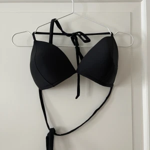 Bikiniöverdel från Nelly - Bikiniöverdel i svart. Från Nelly i storlek L. Vadderade kupor som är insydda. Man knyter om och i nacken. Använd en gång, i fint skick. Bara att fråga om det är något du undrar! Kan mötas på Järntorget i Göteborg eller skicka, köparen står för frakt