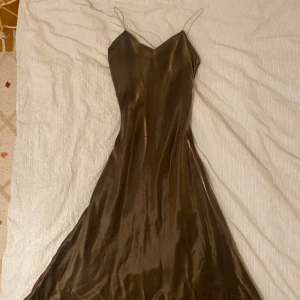 Balklänning/festklänning - Vacker långklänning. Perfekt till balen eller annan tillställning. Skimrar i olika nyanser av guld/svart. Strl S