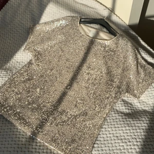 Glittrig t-shirt  - Så fin blus perfekt för nyår eller fest 😍 från hm och använd bara en gång så därför i nyskick. Säljer då den tyvärr inte kommer till användning. Pris kan diskuteras, speciellt vid snabb affär <3