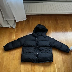 Dunjacka - Puffig dunjacka med inspännes band i midjan. Oanvänd, nypris 750kr