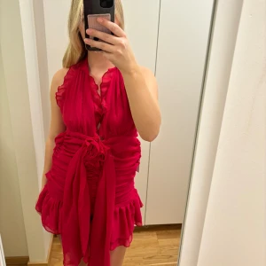 Rosa klänning - Rosa klänning med knytning och volanger, öppen rygg