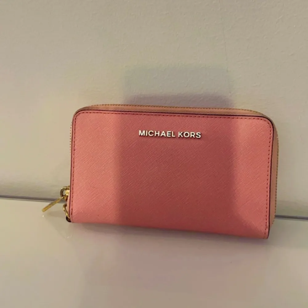Säljer denna snygga plånboken från Michael Kors. I ljusrosa färg, i väldigt gott skick. Pris: 899 kr. Väskor.