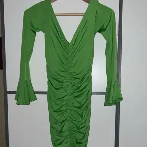 En limegrön klänning som är off-shoulder och lite v-ringad i bysten💚  Klänningen är rynkad på sidorna och på fram och baksida. Den går ner till under knäna. Aldrig använt 